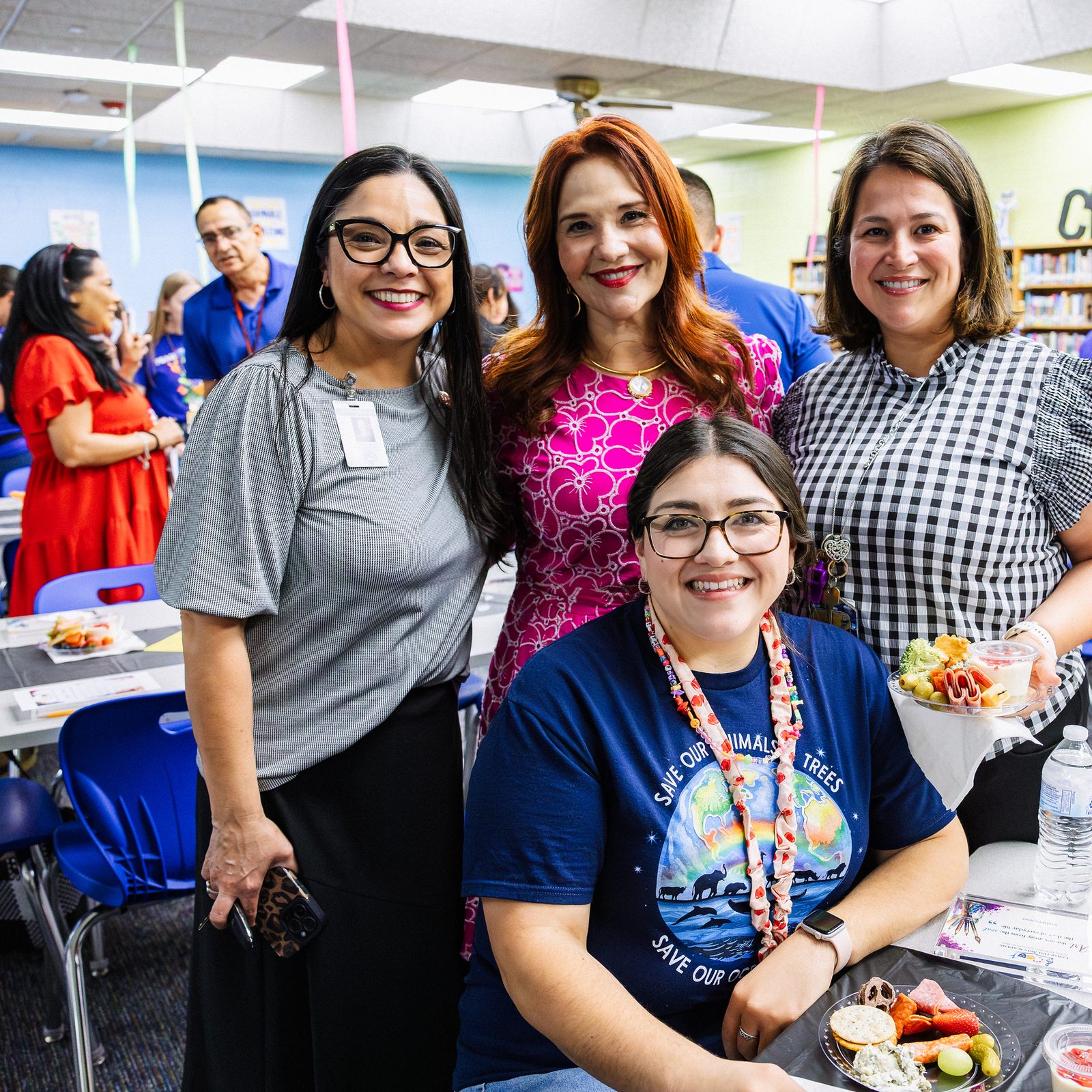 Four HCISD staff members smiling together at the Lamar and Jefferson campus mixer